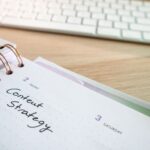 Content strategy written in planner with keyboard on wooden desk