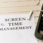 Typewriter with paper titled 'Screen Time Management' on a wooden table.