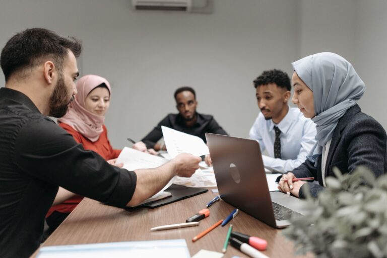 A diverse group of professionals engaging in a collaborative office meeting, sharing ideas and working on a project.