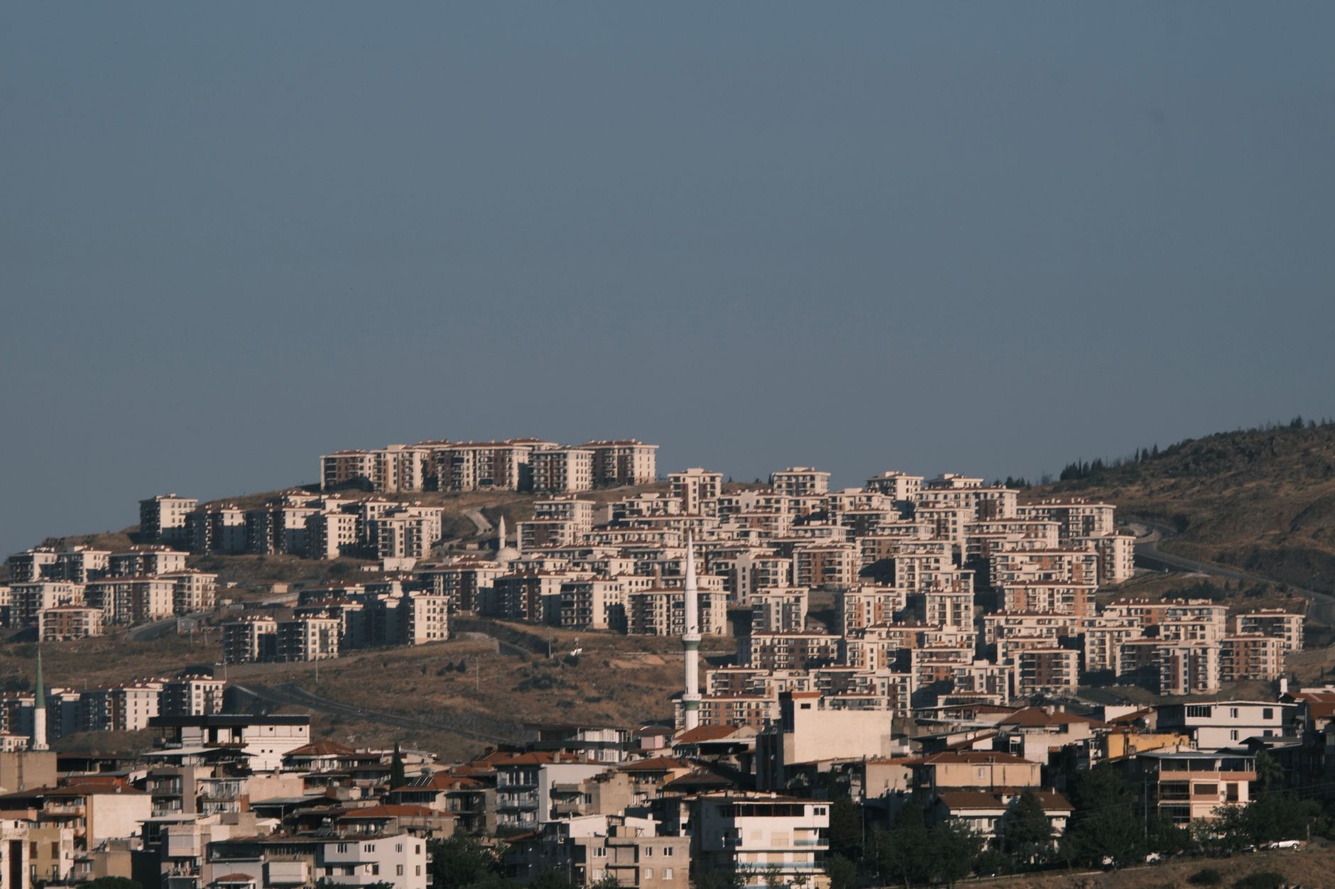 A panoramic view of İzmir, Türkiye showcasing urban residential buildings on a hillside.