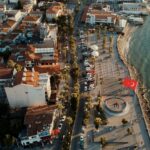Stunning aerial view of Kuşadası, Türkiye, featuring the waterfront and urban architecture at golden hour.
